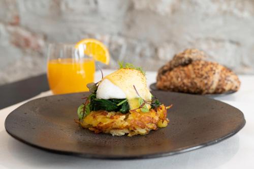 a plate of food on a table with a glass of orange juice at Hotel Des Alpes in Luzern