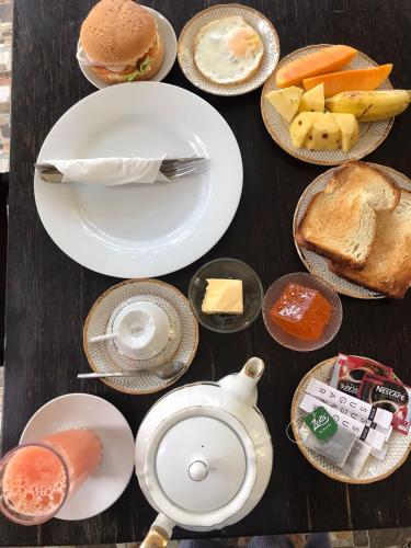 a table topped with plates and bowls of food at Sunnyplace Guest Mirissa in Mirissa