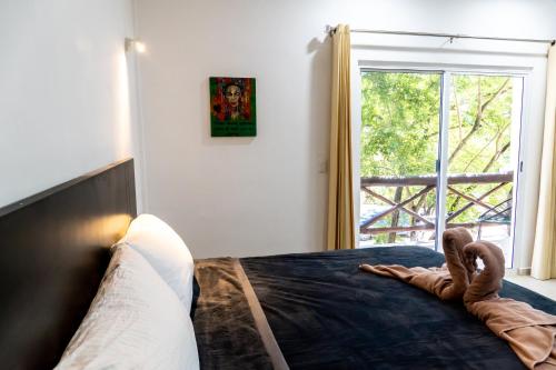 a bedroom with a bed and a window at Hotel Casa Tortuga Tulum - Cenotes Park Inclusive in Tulum