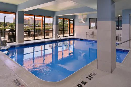 - une grande piscine d'eau bleue dans un bâtiment dans l'établissement Holiday Inn Express Hotel and Suites Mesquite, an IHG Hotel, à Mesquite