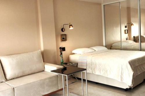 um quarto com 2 camas, um sofá e um espelho em Shopping Piratas, vista para o mar, estacionamento em Angra dos Reis