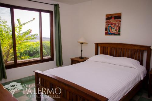 a bedroom with a bed and a large window at Villas de Palermo Hotel and Resort in San Juan del Sur