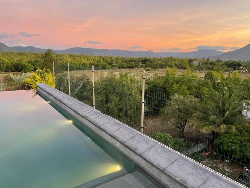 a swimming pool with a view of the mountains at 373 Wolmar Cosy and Modern Apartment- 200 metres from the Beach and Supermarkets and just next to Domaine de wolmar with views of deers and green natural park in Flic-en-Flac
