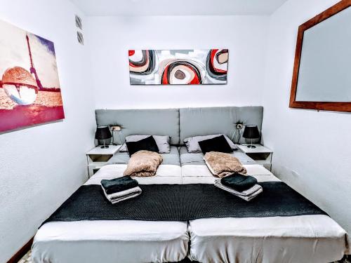 Un dormitorio con una cama con almohadas. en Luxury Newly Refurbished Modern Apartment with Stunning Mountain Views en San Miguel de Abona