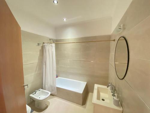 a bathroom with a sink and a toilet and a mirror at La Boya Departamentos in La Paz