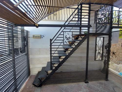 a spiral staircase in a room with wooden blinds at Willa Sandal in Eilat