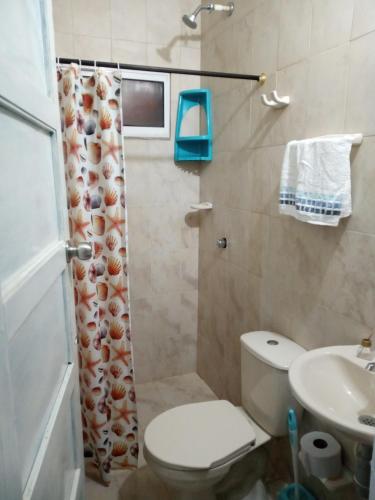 a bathroom with a toilet and a sink and a shower at AquaMarina Hostal in Tolú