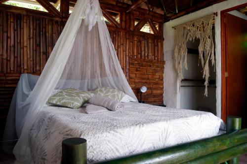 a bed that has a canopy over it at Casa Encuentro Alojamiento Rural in Guatapé