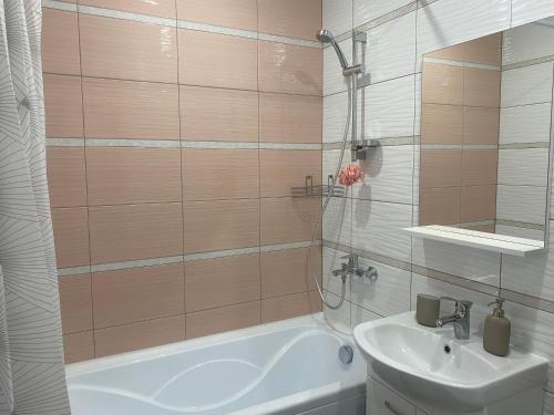 a bathroom with a bath tub and a sink at Уютные апартаменты на Трехсвятской in Tver