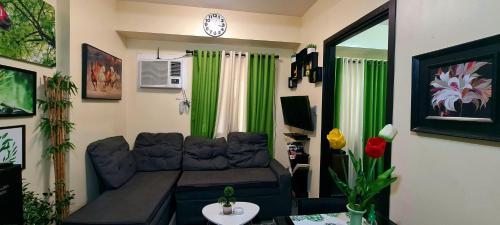 a living room with a couch and green curtains at A Refreshing Condo Unit Near BGC, Ortigas & Makati with NETFLIX and WiFi in Manila