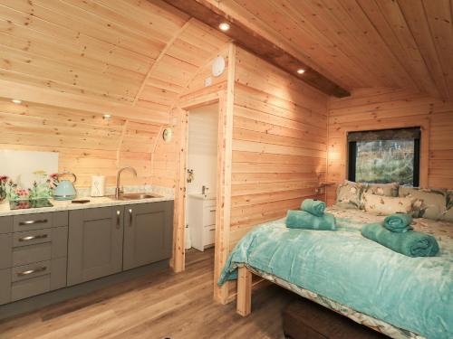 a log cabin bedroom with a bed and a sink at Jenny - Crossgate Luxury Glamping in Penrith