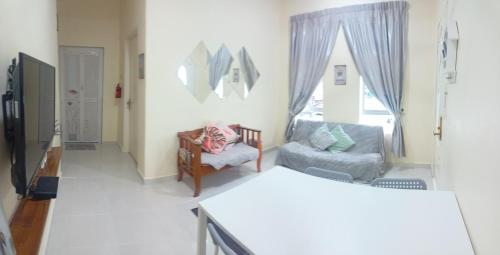 a room with a bed and a chair and a window at Topville Homestay in Kangar