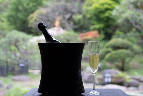 a glass of champagne and a wine bottle in a black holder at Kamakura COCON in Kamakura