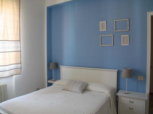 a bedroom with a blue wall and a white bed at Cristina B&B in Sassoferrato