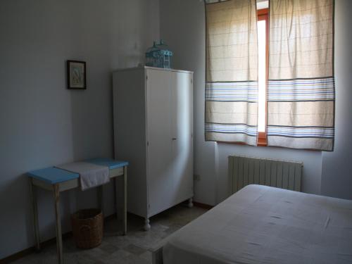 SassoferratoにあるCristina B&Bの冷蔵庫、テーブル、窓が備わる客室です。