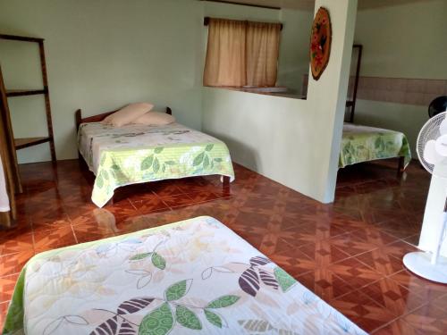 a room with two beds in a room at Posada Rural Río Celeste in Rio Celeste