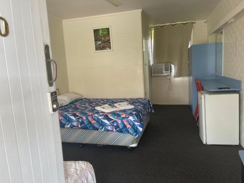 a hotel room with a bed and a refrigerator at Maryborough Motel and Conference Centre in Maryborough