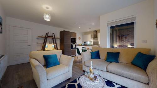a living room with two couches and blue pillows at Luxury 2 Bed Apartment with Parking near London in Swanscombe