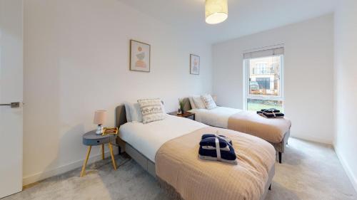 una camera con due letti e una finestra di Luxury 2 Bed Apartment with Parking near London a Swanscombe