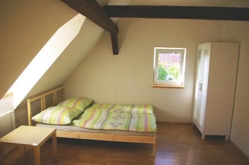 a bedroom with a bed and a window in a attic at Apartmány Růžová in Růžová