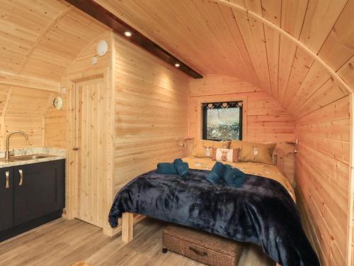 1 dormitorio con 1 cama en una cabaña de madera en The Stag - Crossgate Luxury Glamping, en Penrith