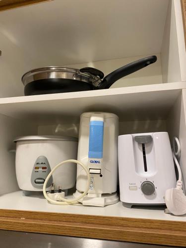 a shelf with various kitchen appliances on it at kuantan staycationtimurbay in Kuantan
