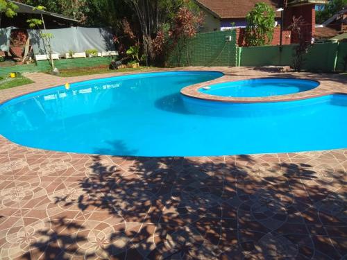 a pool with blue water in a backyard at Steve's House Iguazu Av Cordoba 264 in Puerto Iguazú
