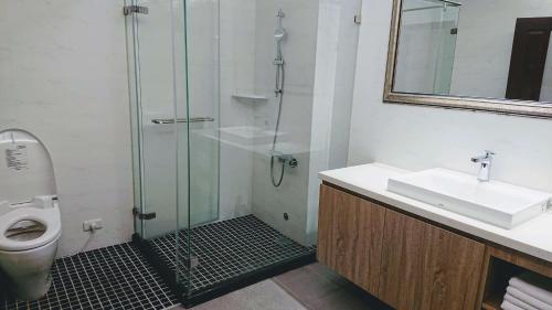 a bathroom with a shower and a sink and a toilet at 胖蝸牛親子民宿 in Tainan