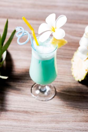 a drink with a flower in a glass on a table at KEP BAY HOTEL & RESORT in Kep