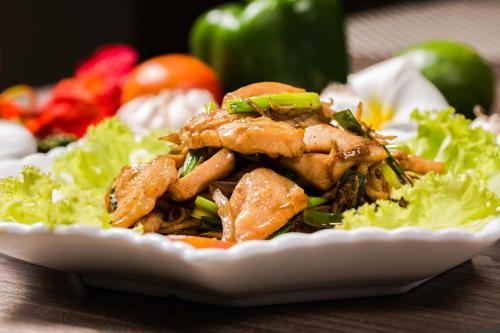 a plate of food with meat and vegetables on a table at KEP BAY HOTEL & RESORT in Kep