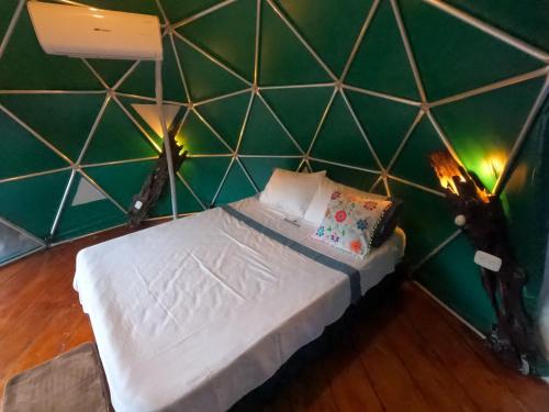 a bedroom with a green wall with a bed in it at Bellavista Experiences - Glamping in Mocoa