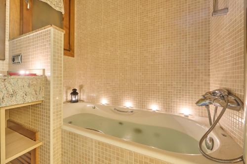 Aparthotel Areu في أريو: حمام مع حوض مع أضواء عليه