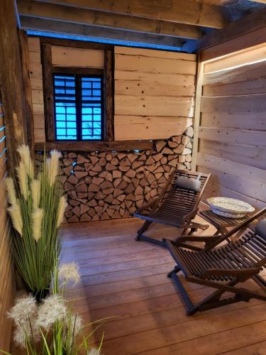 a patio with two chairs and a table in a cabin at Hiša stare mame in Kamnik
