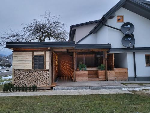 a house with a front porch with wooden logs at Hiša stare mame in Kamnik