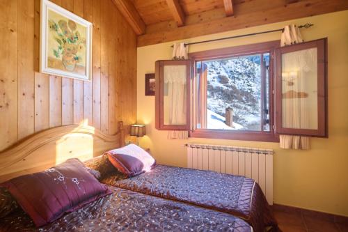 a bedroom with a bed and a window at Aparthotel Areu in Areu