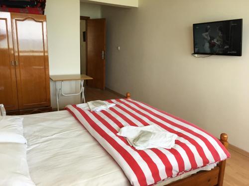 a bed with a red and white striped blanket on it at KOÇAN OTEL Hatice Karakoçan in Akcakoca
