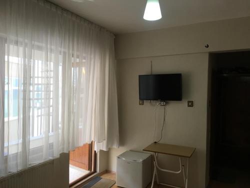 Habitación con TV en la pared y ventana en KOÇAN OTEL Hatice Karakoçan, en Akçakoca