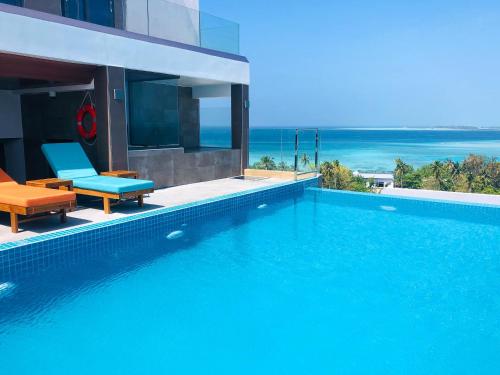 a swimming pool with two chairs and the ocean at Triton Prestige Seaview and Spa in Maafushi
