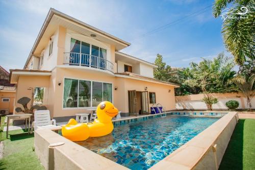 a house with a pool with two rubber ducks in the yard at TY Holiday Resort in Pattaya