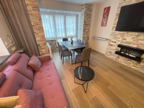 a living room with a couch and a table with chairs at Immodelpas Pessons in Pas de la Casa