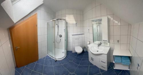 a bathroom with a shower and a sink and a toilet at Ferienwohnung Schmid in Sankt Martin am Grimming