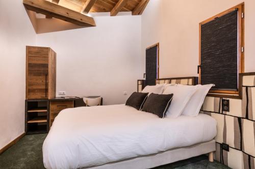 1 dormitorio con cama blanca y escritorio en Wanderful Life Les Arcs refuge haut de gamme, en Arc 1600