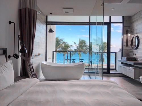 a bedroom with a tub and a view of the ocean at Before Sunrise Seaview B&B in Hualien City