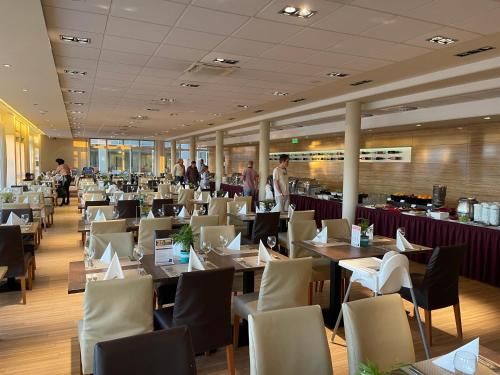 a restaurant with tables and chairs and people in the background at Velence Sunset Wellness Apartman in Velence