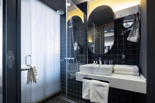 een badkamer met een wastafel en een spiegel bij ibis Almaty Jetisu in Alma-Ata