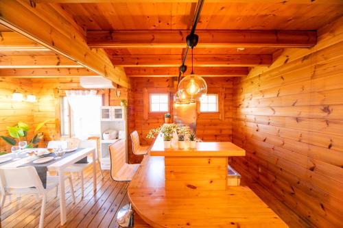 a kitchen and dining room with a wooden wall at Awaji Seaside Log house in Goshiki 1 in Sumoto