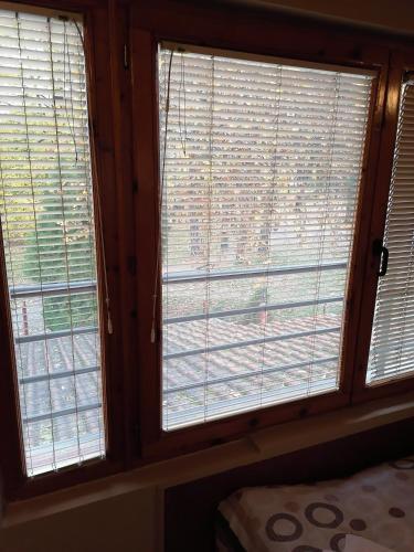 two windows in a room with blinds on them at S Centro - park apartmani in Kraljevo
