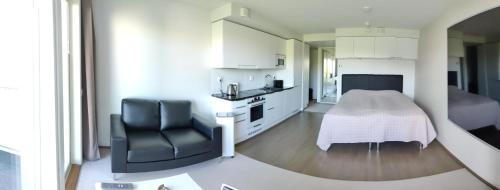 uma sala de estar com uma cadeira e uma cozinha em Eerikinpiha Residence em Turku