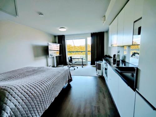um quarto com uma cama, um lavatório e uma cozinha em Eerikinpiha Residence em Turku