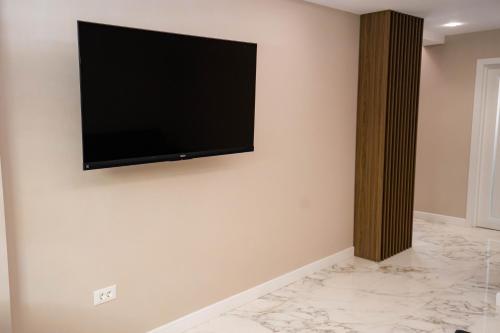 a flat screen tv hanging on a wall at Deluxe Aparthotel MARWELL RESIDENCE in Suceava